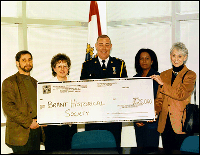 Image of Chief Peeling presenting a ceremonial donation cheque to the Brant Historical Society